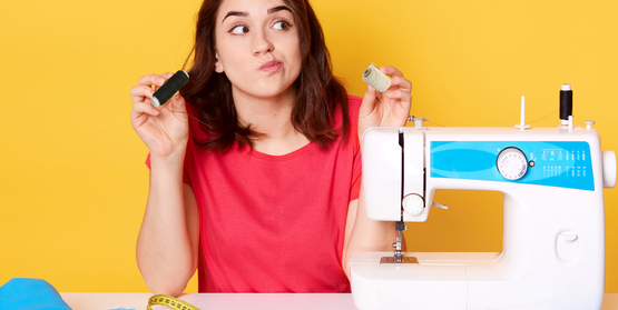 Woman looking perplexed in front of sewing machine