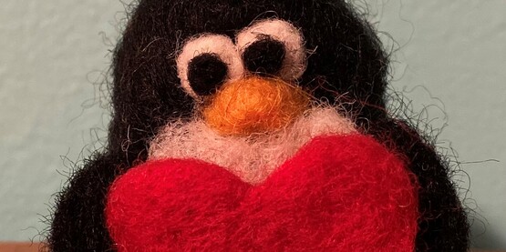 Needle felted penguin with a heart