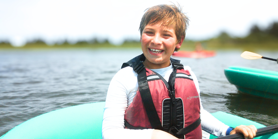A happy camper paddling on the bay