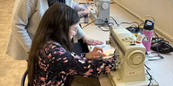 youth sewing with volunteer