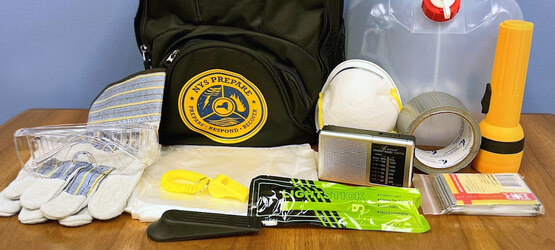 A collection of emergency items including gloves, eye protection, a face mask, tape, a flashlight, and more.
