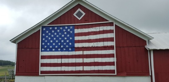 US Flag on red barn on farm
