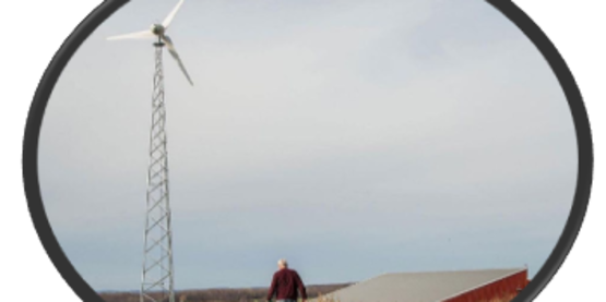 A farmer with a wind turbine in the field
