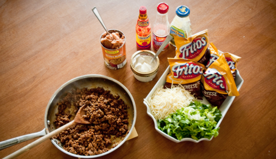 ground beef, fritos, cheese, tomatoes, lettuce and hot sauce used to make "walking tacos"