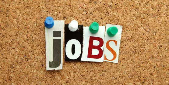 the word "jobs" spelled with push-pins and cut out letters on a cork bulletin board