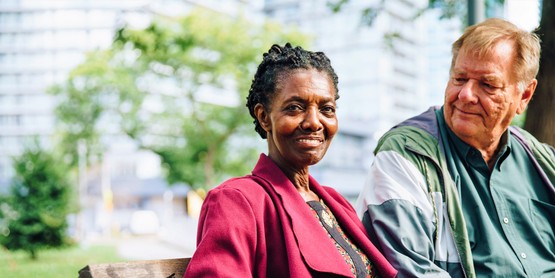 Aging adult couple sitting on bench. 