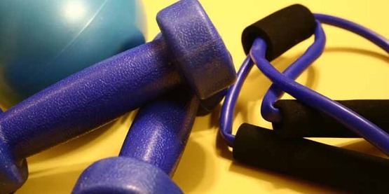 exercise equipment including a turquoise rubber ball, a pair of light-weight dumbbells, and an elastic jump rope