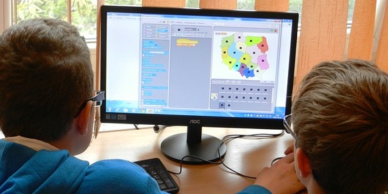 Two kids using desktop computer 