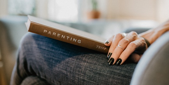 Parenting book on a woman's lap