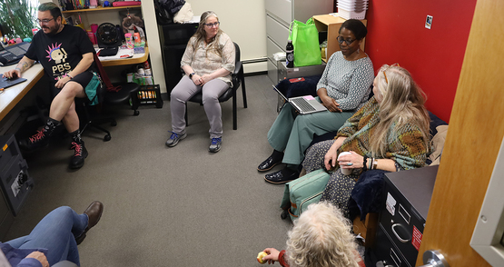 A group of people sitting in a circle in a small but comfortable office.