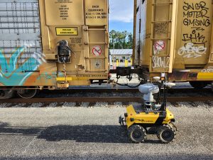 Husky Observer taking photo of train car links