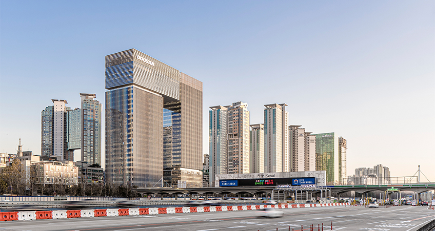 Comprising two towers connected by a 100-meter-tall skybridge, the new building forms an iconic landmark on its prime site near the main tollgate to and from Seoul.