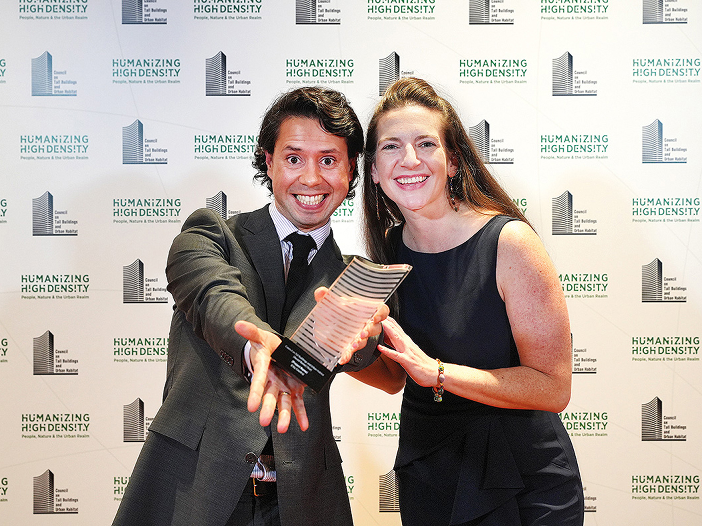 Two people holding a CVU trophy
