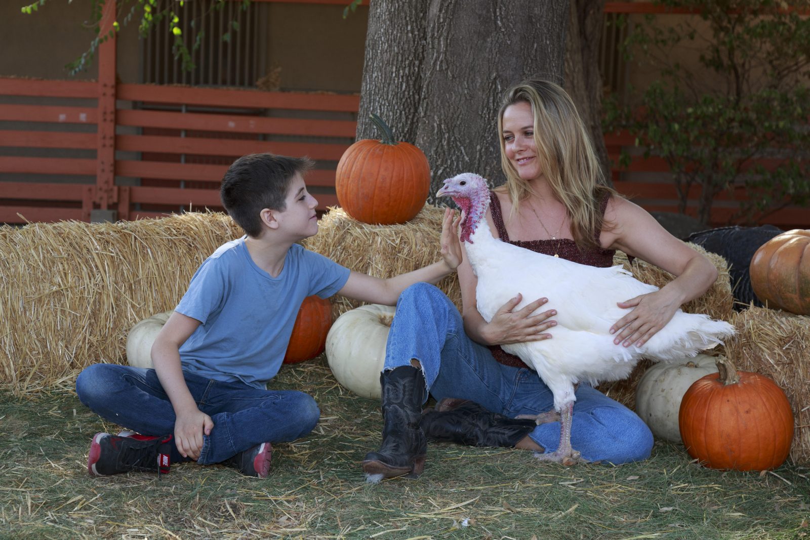 Alicia Silverstone and Bear Blu with a turkey at Farm Sanctuary