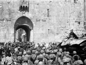 Israeli soldiers file past a burnt vehicle as they enter the Lions’ Gate (or St Stephen’s Gate), Old City of Jerusalem, Israel, June 11, 1967.