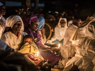 Believers of Legio Maria of African Church Mission hold candles during their overnight Christmas Mass at the church near Ugunja, the western part of Kenya, early December 25, 2017.