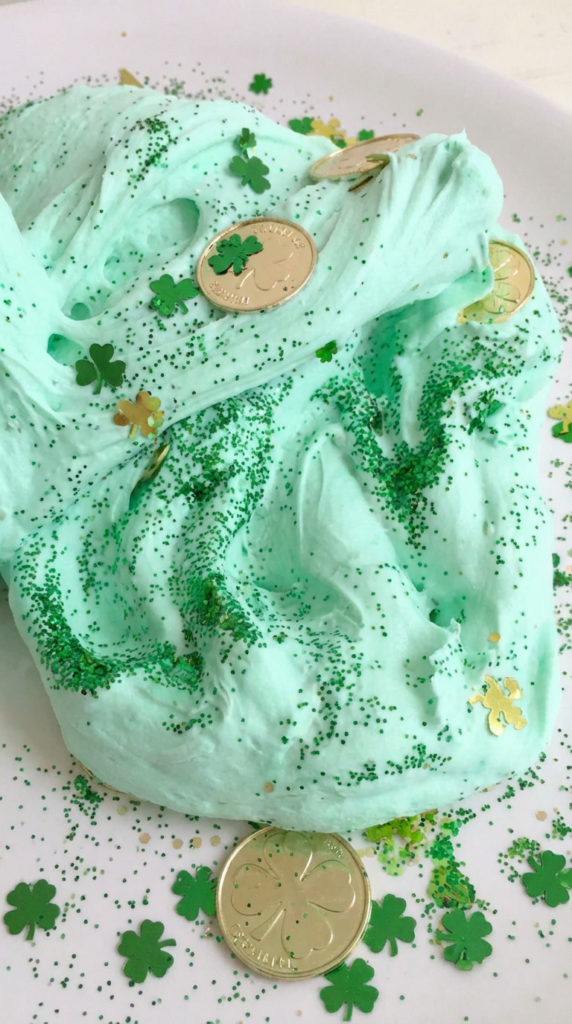 Fluffy green St. Patrick’s Day slime with gold coins and glitter in a bowl