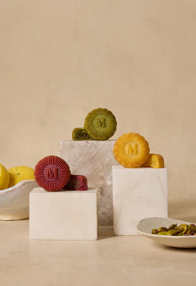 Handcrafted mooncakes in three exclusive flavors arranged on marble pedestals