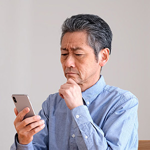 Image of a senior man squinting at his smartphone