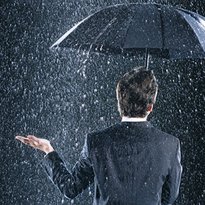 Image of an investor staying dry under an umbrella