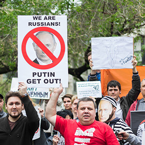 Image of protestors holding a sign that reads %22We are Russians! Putin, get out!%22