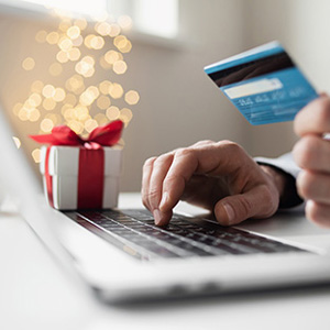 Image of a person using a credit card to shop online during the holidays