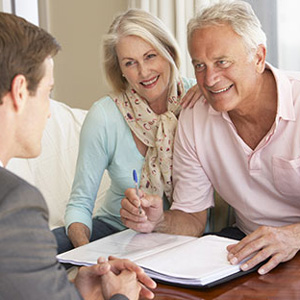 Image of an elderly couple meeting with an advisor