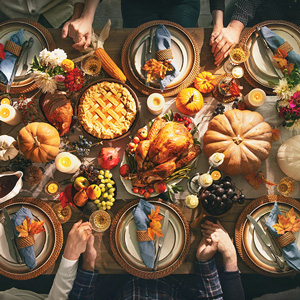 Image of family members giving thanks at the dinner table