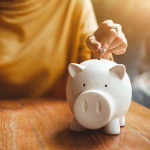Image of a woman putting money into a piggy bank