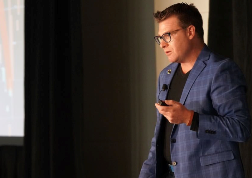 Bryan speaking on stage