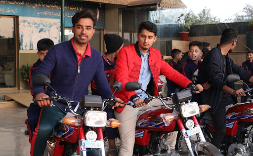 Uni students sitting on their newly gifted bike at PSH