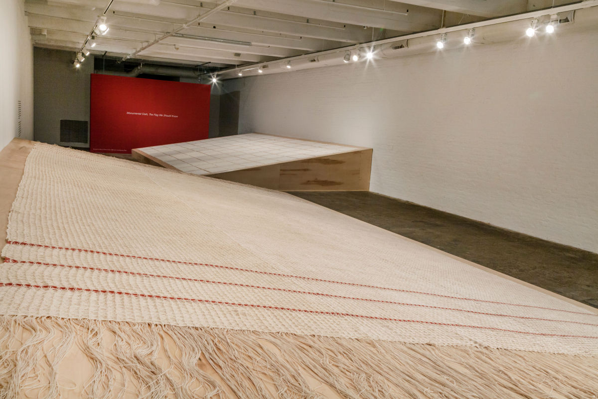 Large scale installation of fabric made of woven linen with madder dye, on a wodden board.
