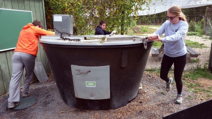 Students rotating the composting unit at the back campus garden during Nabors Service Day.