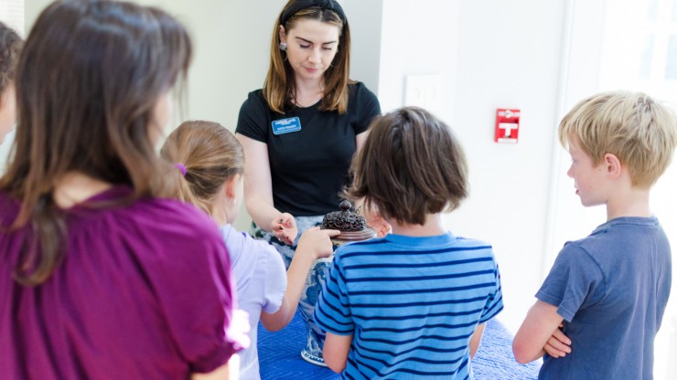 Children attending a family day get a lesson in handling ceramics