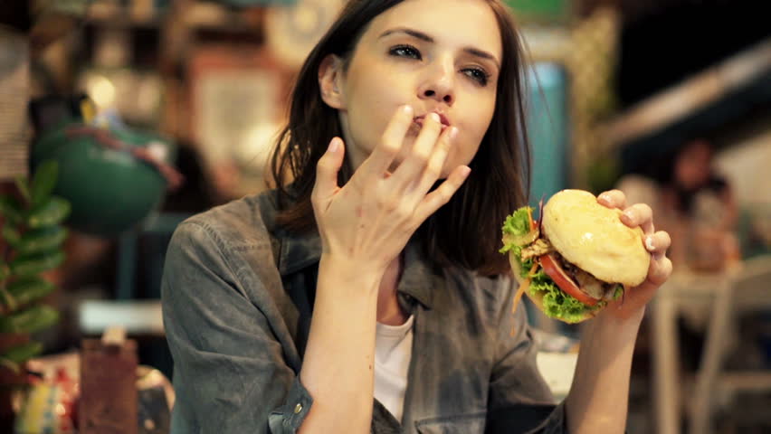 woman in 20s eating junk food