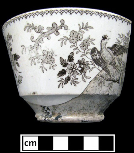 Brown transferware cup from Maryland. Bat printing worked well for irregularly shaped and small vessels since the bat easily fit along tight surfaces, meaning the sherd could have been something like a teacup or lid.