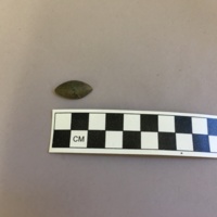 Front view of pewter button excavated from unit H931, Level 3, depth of 68-80cm. Note the plainness of the button and the absence of decorative detail.