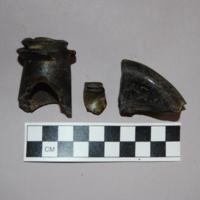 These broken shards come from the stem and base of an 19th century dark green wine bottle. We were able to date it by estimating the circumference of the base. Students at the college would have stored and drank this wine despite specific rules against doing so set by the University.