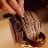 A comb is drawn through wet white slip to create peaks and troughs in this example of the combing technique.