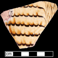 North Midlands/Staffordshire-type slipware sherd collected by George L. Miller in 1986 in Staffordshire, England. Note the distinct wave pattern we also see on our sherd.
