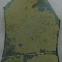 Glass fragment with patinated surface, a feature caused by the interactions between  ions in the glass and moisture in the soil.