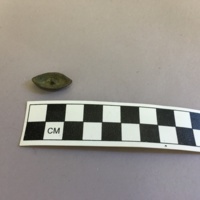 Back view of pewter button excavated from unit H931, Level 3, depth of 68-80cm. This view shows the hollow back and where the shank would have been attached.
