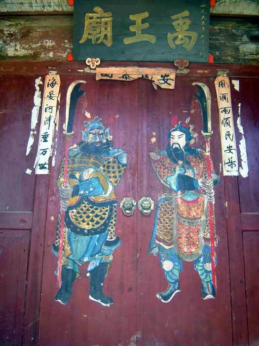 Entrance door of Yuwang Temple. The plaque says `Yuwang Temple`. Two gate guardian gods are depicted on the door.