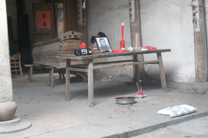 view of coffin, offering table, incense and kneeling mat