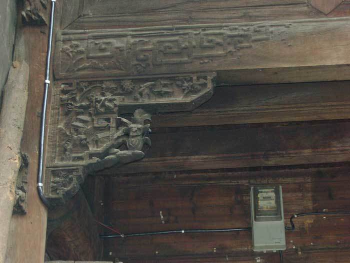 Carved bracket with rural themes on the left-hand side (1st pillar)