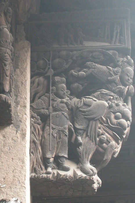 man on mythical beast; wooden bas relief