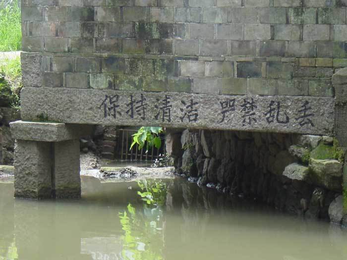 Column and writing in and above water at back of temple
