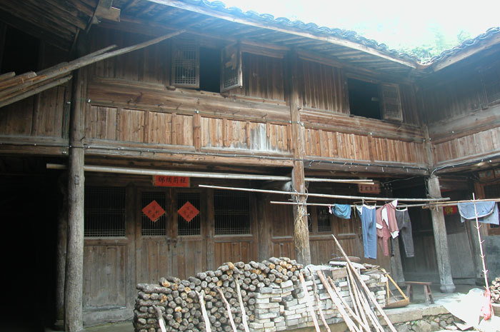Left side view of the back hall with upper storey windows and mushroom growing logs in foreground