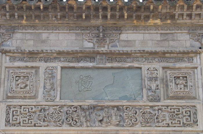 Plaque and stonework of the left door