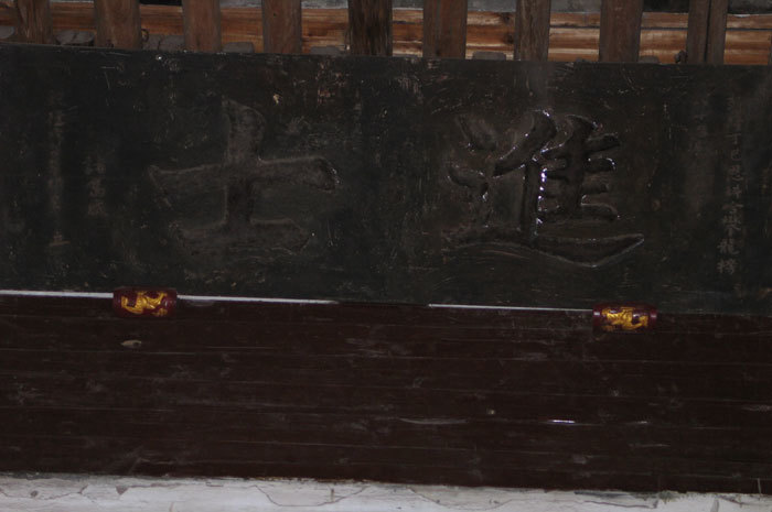 Characters above plaque, left side rear Characters above plaque, left side rear